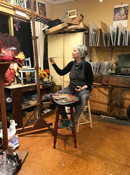 Woman painting at easel in art studio